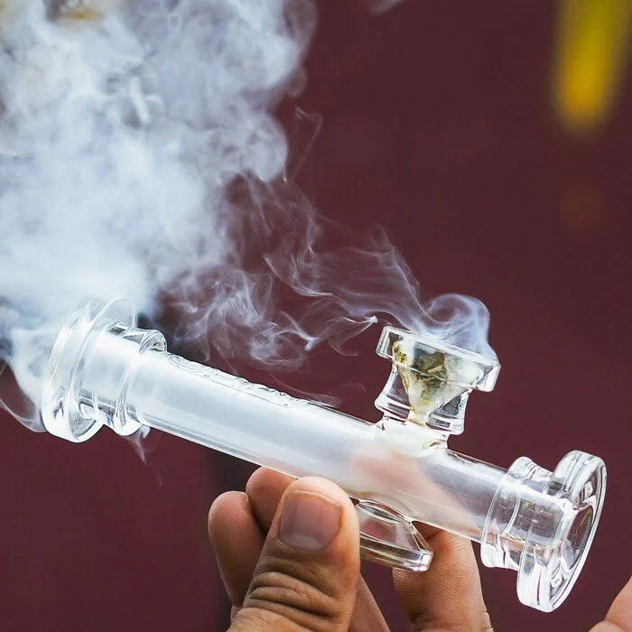 cookies cookie bite hand pipe in use in someone's hand with smoke surrounding it