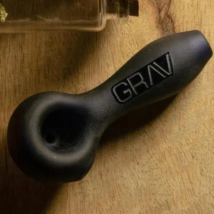 Black glass weed pipe sitting on a table