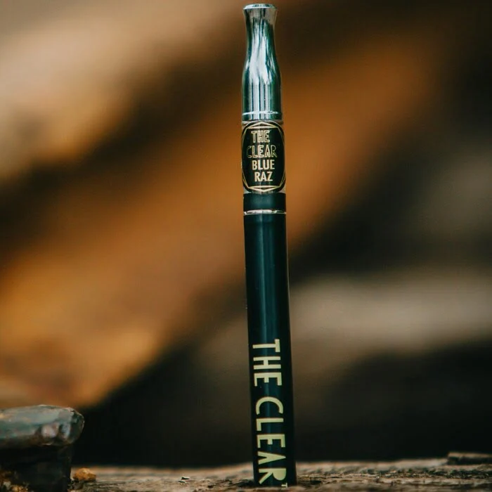 dual chamber dab pen sitting on a log in the forest