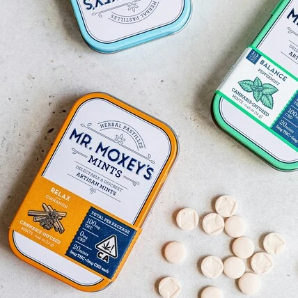 image of mr. moxey's dream lavender THC mints in boxes with mints spilled out onto a white backdrop